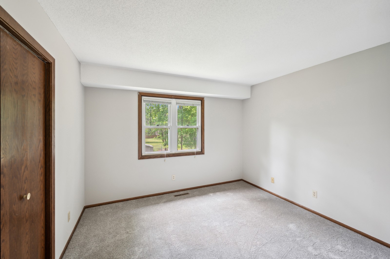 Inviting bedroom at Blossom Hill Assisted Living featuring a cozy bed, large window, and warm décor